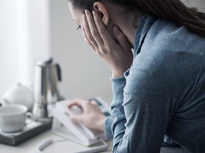 stressed woman thinks about making a phone call to anxiety hotline