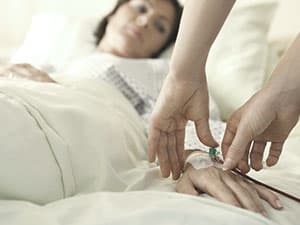 Girl in hospital bed with IV in arm