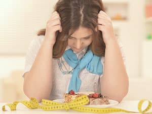 Girl staring at food on plate