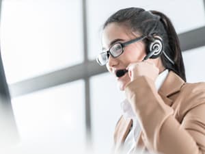 Professional woman at hotline talks on a headset