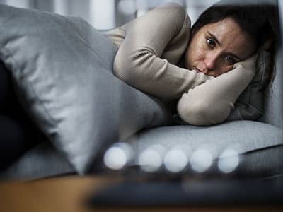 Woman laying in bed looking anxious